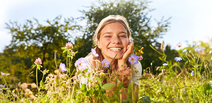 Jugendliche liegt auf einer blühenden Blumenwiese